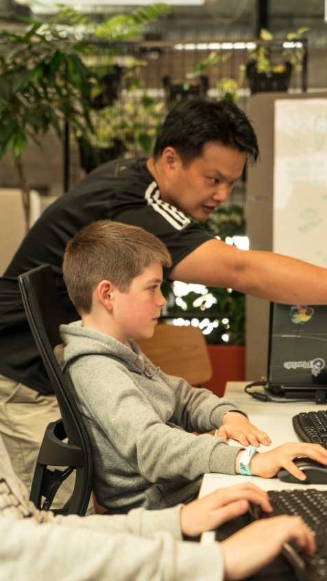 A Kids Game Dev tutor helping a student build a game